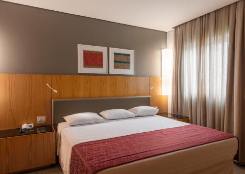 圣保罗DELPLAZA Marabá São Paulo的一间卧室配有一张带红色毯子的大床