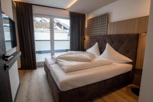 伊施格尔Place2be的卧室配有一张带白色床单和枕头的大床。