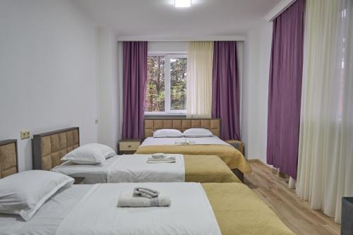 KhuloHotel Lile • სასტუმრო ლილე的酒店客房设有两张床和窗户。