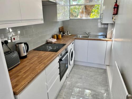 伦敦Affordable 2 bedroom flat Tower Bridge/Bermondsey的白色的厨房设有水槽和炉灶。