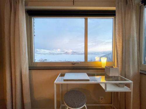 里克斯格伦森Ski in ski out lägenhet med fantastisk utsikt的一张位于大窗户前的桌子,配有一台笔记本电脑