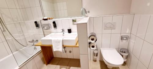 多瑙河畔克雷姆斯Wirtshaus Leindl的白色的浴室设有水槽和卫生间。