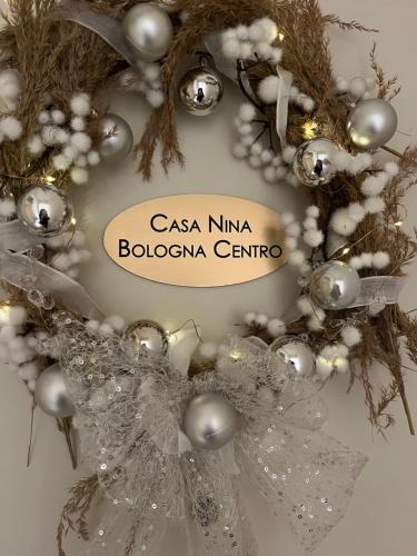 博洛尼亚Casa Nina Bologna Centro的一种带读csa kmina bolota的符号的圣诞花圈