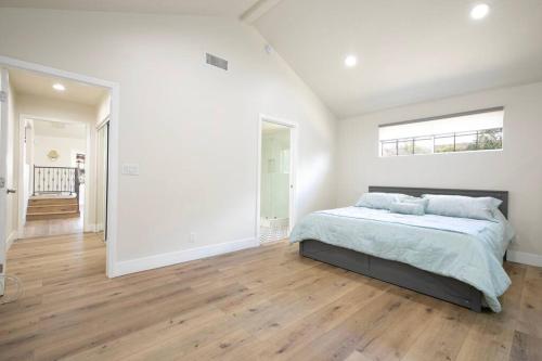 洛杉矶Beautiful Spacious Home的白色的卧室设有床和大窗户