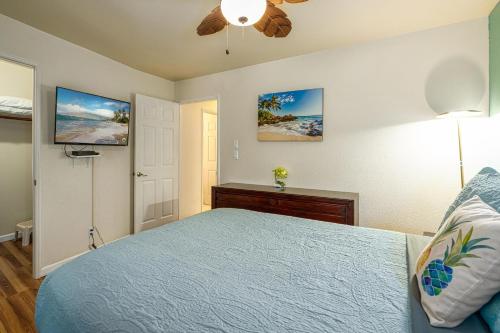 基黑Kihei Bay Vista B-102, Beautifully renovated, AC!的一间卧室配有蓝色的床和吊扇