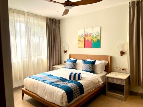 威廉斯塔德Xanadu Apartments at Blue Bay Golf & Beach Resort的一间卧室配有一张带蓝色和白色枕头的床