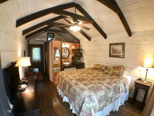 赛维尔维尔Tiny Home Cottage Near the Smokies #1 Olga的一间卧室配有一张大床和两盏灯。