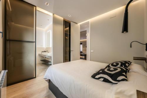 马德里En el corazón de Madrid, casa Moderna的卧室配有一张带黑色枕头的白色床