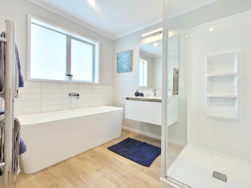 怀蒂昂格Hosts on the Coast - Bright New Delight on Kupe的白色的浴室设有浴缸和窗户。