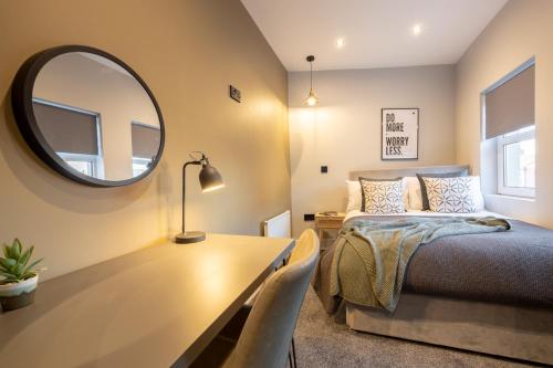 贝尔法斯特Harland House的一间卧室配有一张床和一张带镜子的桌子