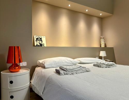 米斯泰尔比安科Casa Cavour的一间卧室配有一张带白色床单和一盏灯的床。
