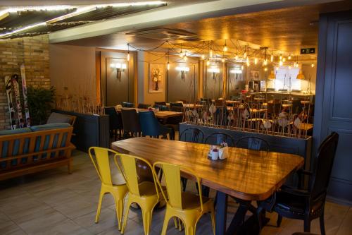埃尔祖鲁姆扎德酒店的一间带木桌和黄色椅子的用餐室