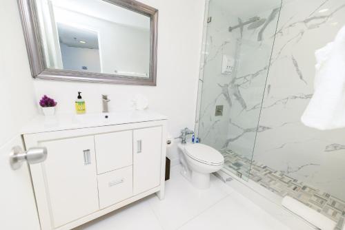 迈阿密海滩SeaStays Apartments的带淋浴和卫生间的白色浴室