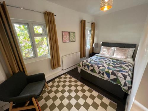 伦敦Cozy 2 bedroom flat Tower Bridge / Bermondsey的卧室配有床、椅子和窗户。