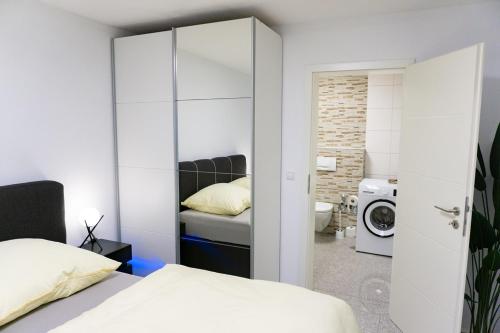 AlfterCharmante und stilvolle Wohnung的一间卧室配有一张床,浴室内配备有洗衣机