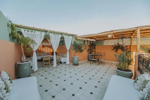 马拉喀什Riad Dar Coram的一个带盆栽和桌子的庭院