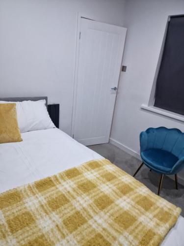 Sheriff HillCosy and Unique Bedroom In Gateshead的一间卧室配有一张床和一张蓝色椅子