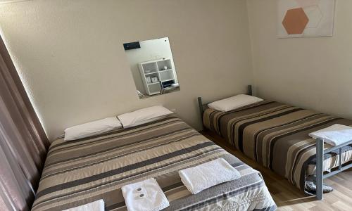 圣乔治St George Hotel Motel的小房间设有两张床和镜子