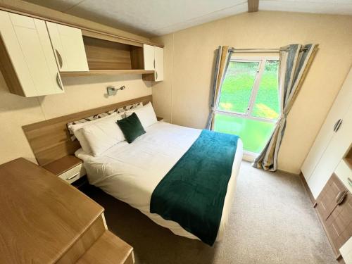 尚克林Luxury 2 Bedroom Caravan LG13, Shanklin, Isle of Wight的一间小卧室,配有床和窗户
