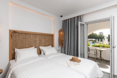 纳克索乔拉纳克索斯岛海滩度假酒店的一间带一张白色大床的卧室和一个阳台