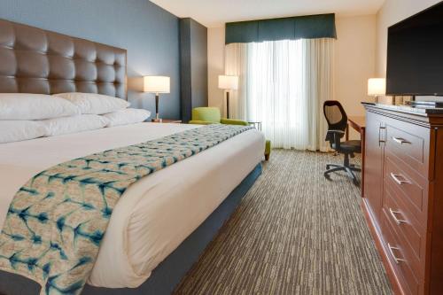 哥伦比亚Drury Plaza Hotel Columbia East的酒店客房设有一张大床和一张书桌。