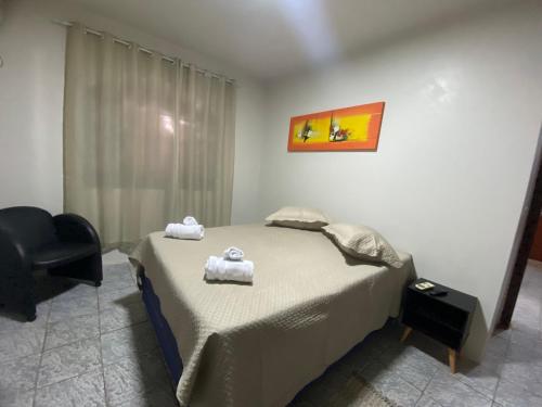 伊瓜苏Espaço confortável no centro da cidade的一间卧室配有一张床,上面有两条毛巾