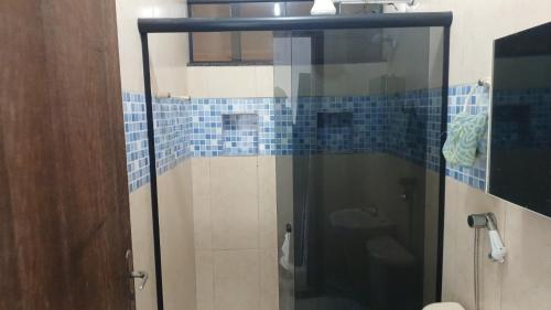 Rio Grande da SerraRo Rooms的浴室设有蓝色瓷砖玻璃淋浴间
