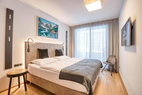 湖城Exklusiv und elegantes Apartment in der Residenz Silvretta inkl Silvretta Premium Summer Card的一间卧室设有一张大床和一个窗户。