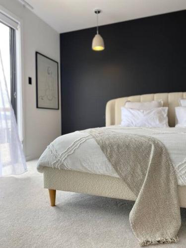 圣海伦斯'Shore Thing' - Akaroa的一间卧室配有一张床铺,床上有毯子