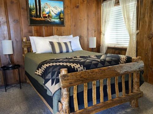 大熊湖2410 - Oak Knoll Duplex Studio #12 cabin的木制客房内的一间卧室,配有一张床