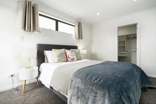 汉密尔顿Stunning 3 bedrooms house in Hillcrest - Close to Waikato University & Cambridge的白色卧室设有大床和窗户