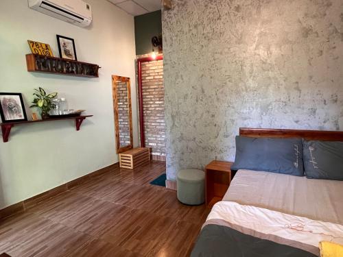 Ðông Tác (1)Trại Hoa Vàng Homestay at Tuy Hòa Phú Yên的一间卧室设有一张床和砖墙
