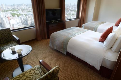 东京东京大都会大饭店的一间酒店客房,配有一张床和一台电视