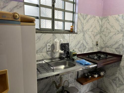 马瑙斯Luso Apartamentos的厨房柜台设有水槽和炉灶。