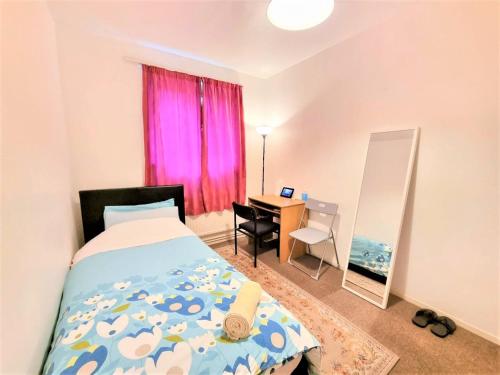 伦敦London Rooms的一间卧室配有一张床和一张带粉红色窗户的书桌