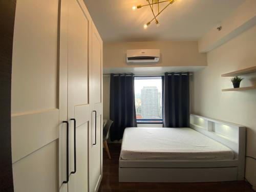 马尼拉Air Residences 4439的一间小卧室,配有床和窗户