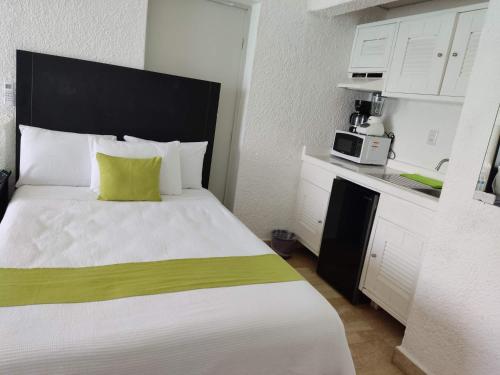 坎昆“Magic Sunrise at Cancun”的一间卧室配有一张大床和一台微波炉