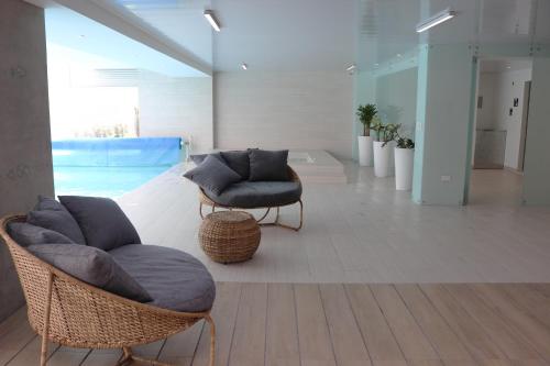 基多Acqualina Studios and Suites by Check-in Ec.的一间带两把椅子和游泳池的客厅