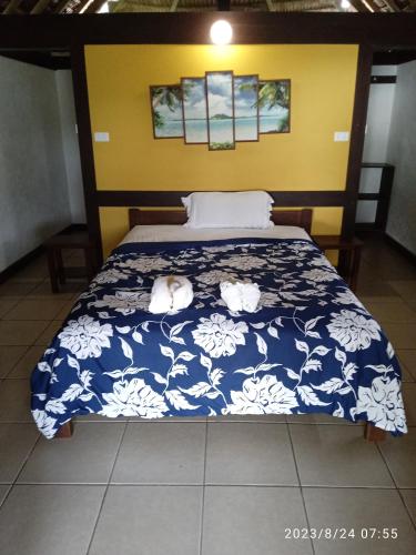 Port-OlrySerenity Bungalows的一间卧室配有一张带蓝色和白色棉被的床