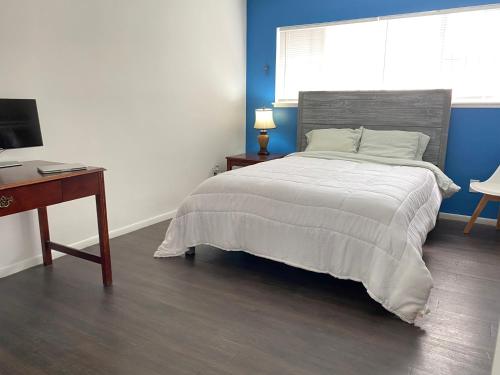 长滩Modern Stay - Private Room的一间卧室配有一张床、一张书桌和一台电视