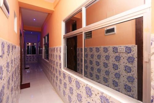 普里Goroomgo Savashi Puri的浴室的走廊铺有蓝色和白色瓷砖