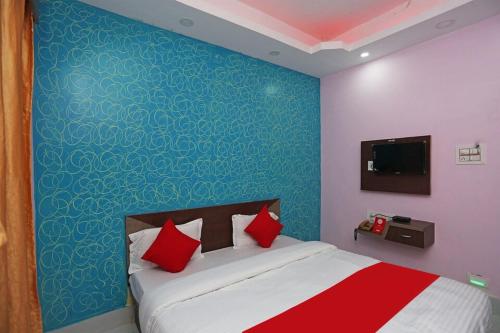 普里Goroomgo Savashi Puri的一间卧室配有一张蓝色墙壁的床
