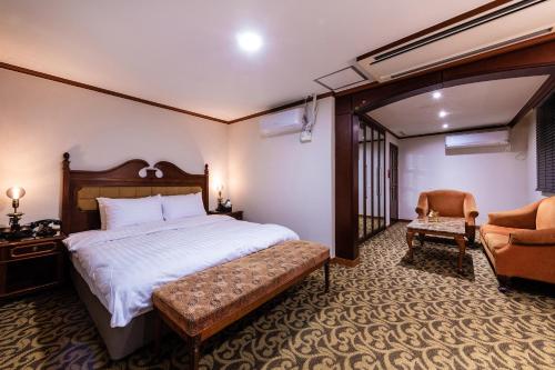 首尔New Cheonji Hotel的配有一张床和一把椅子的酒店客房