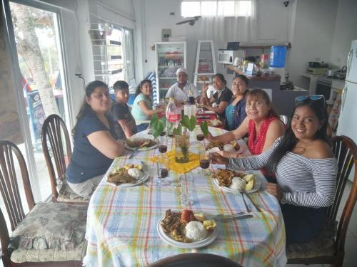 巴克里索莫雷诺港Hostal Cabañas Don Jorge的一群人坐在桌子旁吃着食物