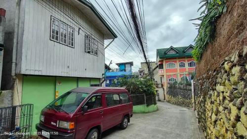 碧瑶Kochimoto Homestay的停在大楼旁边的红色小汽车