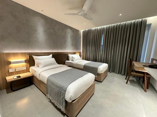 海得拉巴32 Urban by Akoya Hotels的酒店客房配有两张床和一张书桌