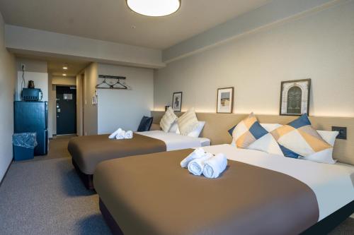 大阪Apartment Hotel 11 Namba Minami III的酒店客房 - 带两张床和毛巾