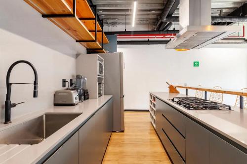 墨西哥城Mariano Escobedo 48的厨房配有白色柜台和不锈钢用具
