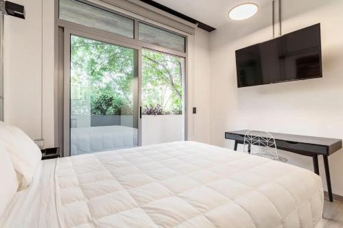 墨西哥城Mariano Escobedo 48的卧室配有一张白色大床和一张书桌