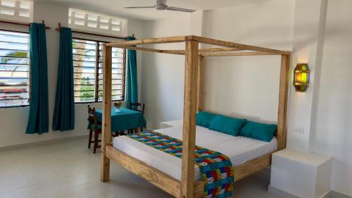 MsambweniSawa Sawa Beach House的一间卧室配有一张木床和天篷